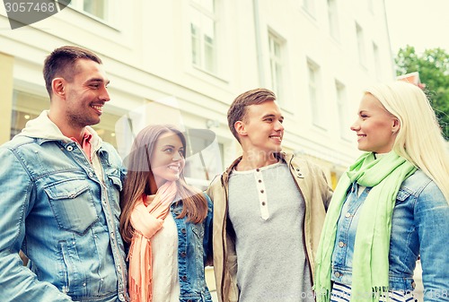 Image of group of smiling friends walking in the city