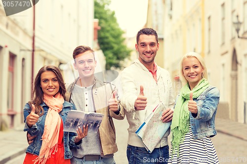 Image of group of smiling friends with city guide and map