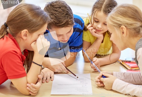 Image of group of students talking and writing at school