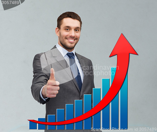 Image of smiling young businessman showing thumbs up