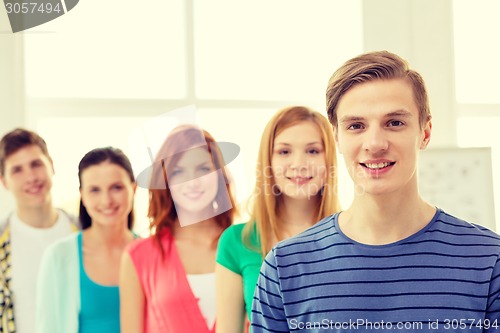 Image of smiling students with teenage boy in front