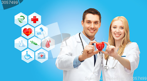 Image of smiling doctors cardiologists with small red heart