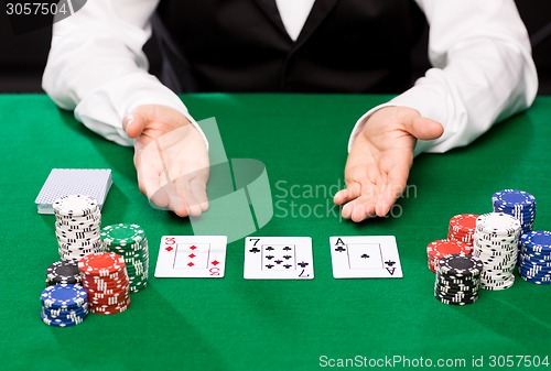 Image of holdem dealer with playing cards and casino chips