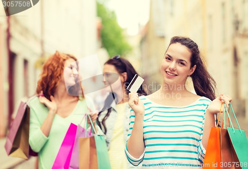 Image of smiling teenage girls with shopping bags on street