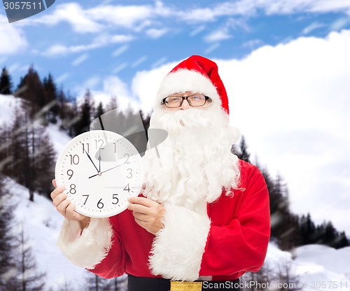 Image of man in costume of santa claus with clock