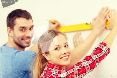 Image of couple building using spirit level to measure