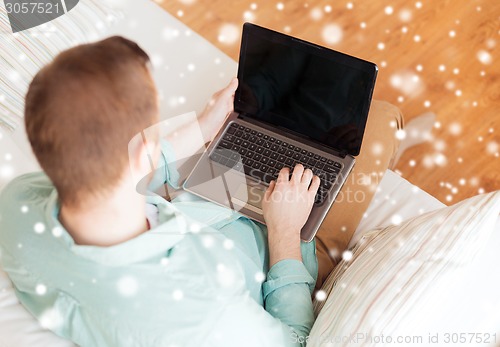 Image of close up of man working with laptop at home