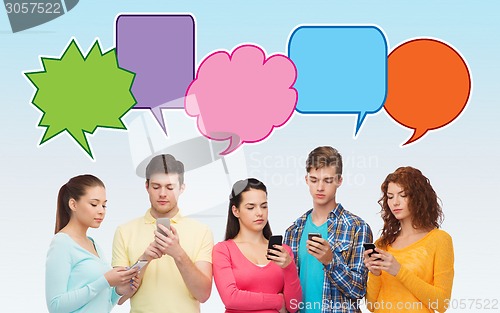 Image of group of serious teenagers with smartphones