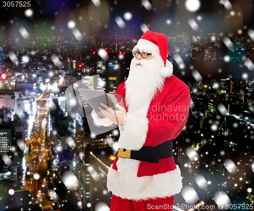 Image of man in costume of santa claus with tablet pc