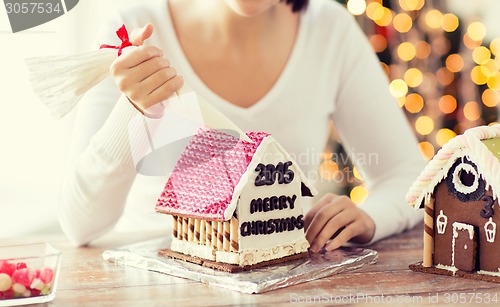 Image of close up of woman making gingerbread houses