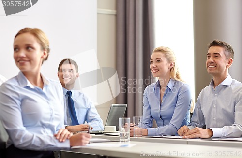 Image of group of smiling businesspeople meeting in office