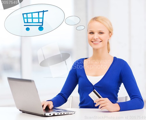 Image of smiling woman with laptop computer and credit card