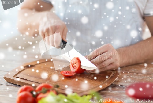 Image of close up of man cutting vegetables with knife