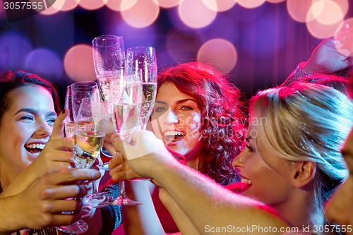 Image of smiling friends with glasses of champagne in club