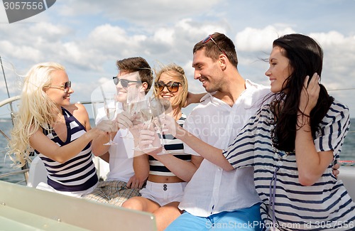 Image of smiling friends with glasses of champagne on yacht