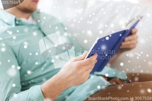 Image of close up of man reading book at home