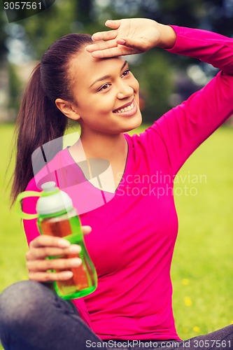 Image of smiling teenage girl showing bottle