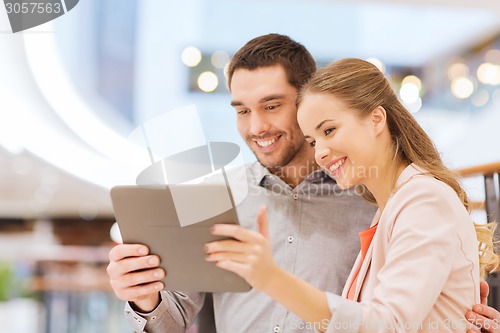 Image of happy couple with tablet pc taking selfie in mall