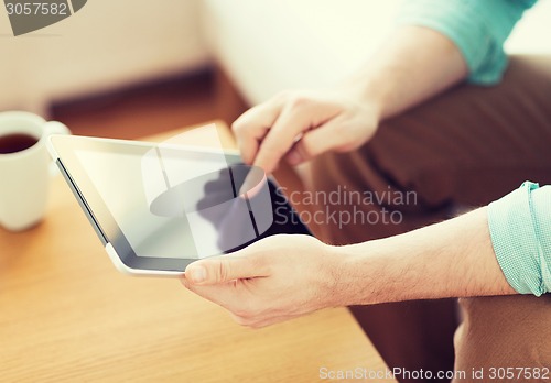 Image of close up of man with laptop and cup at home