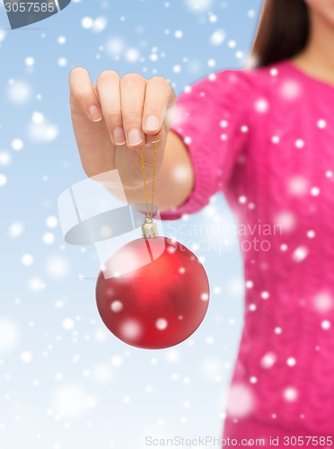 Image of close up of woman in sweater with christmas ball