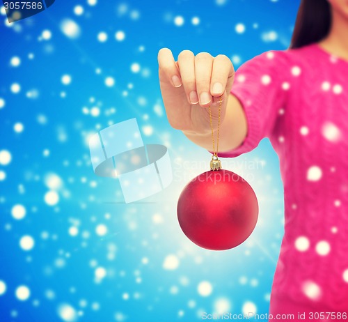 Image of close up of woman in sweater with christmas ball