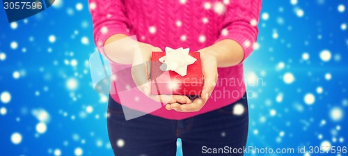 Image of close up of woman in pink sweater holding gift box