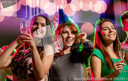 Image of smiling friends with glasses of champagne in club