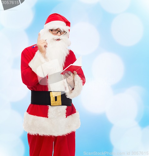 Image of man in costume of santa claus with notepad