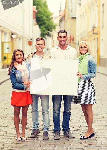 Image of group of smiling friends with blank white board