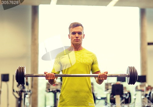 Image of man doing exercise with barbell in gym