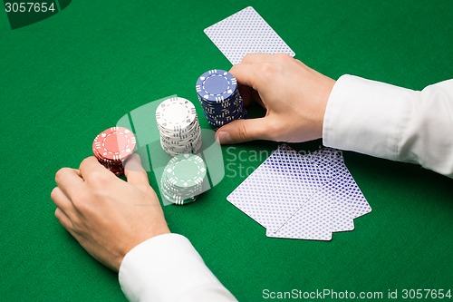 Image of holdem dealer with playing cards and casino chips