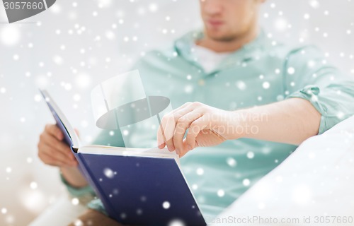 Image of close up of man reading book at home