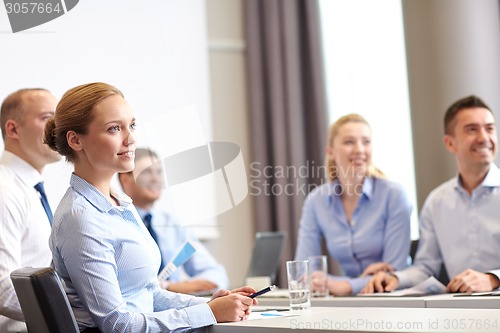 Image of group of smiling businesspeople meeting in office