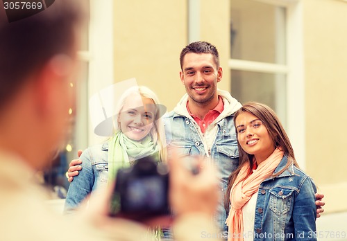 Image of group of smiling friends taking photo outdoors