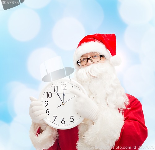 Image of man in costume of santa claus with clock