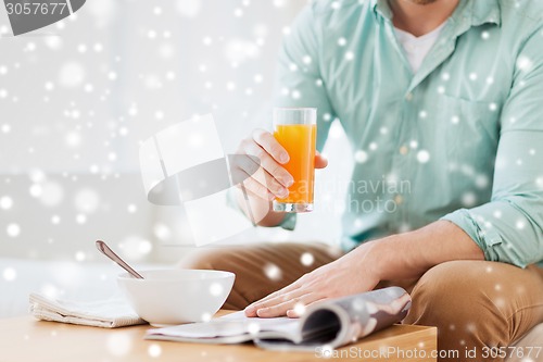 Image of close up of man with magazine drinking juice