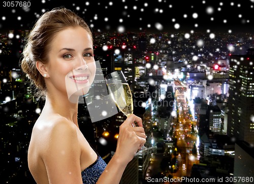 Image of smiling woman holding glass of sparkling wine