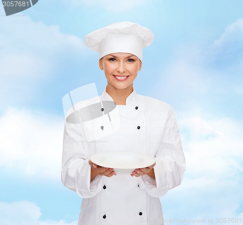 Image of smiling female chef with empty plate