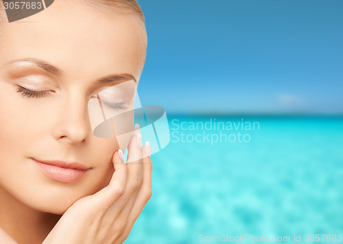 Image of beautiful young woman touching her face