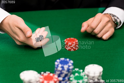 Image of poker player with dice and chips at casino