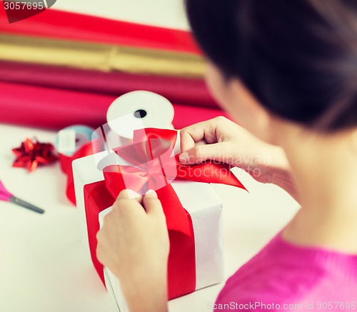 Image of close up of woman decorating christmas presents