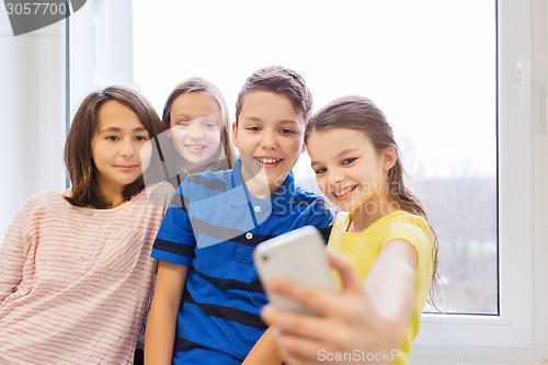 Image of group of school kids taking selfie with smartphone