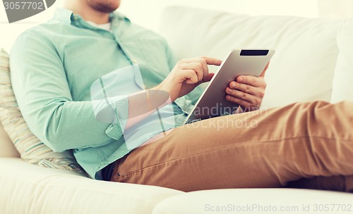 Image of close up of man with tablet pc computer at home