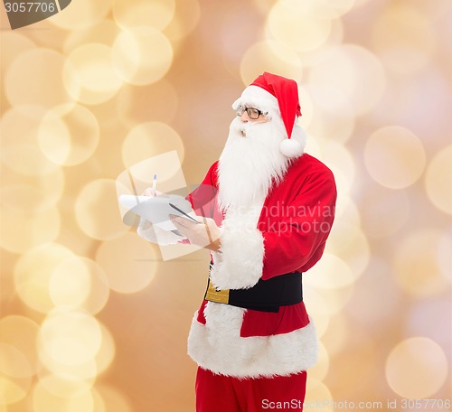 Image of man in costume of santa claus with notepad