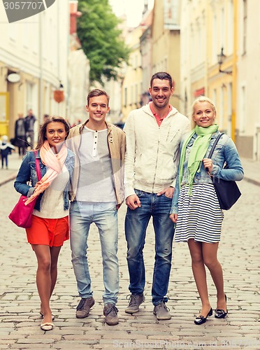 Image of group of smiling friends walking in the city