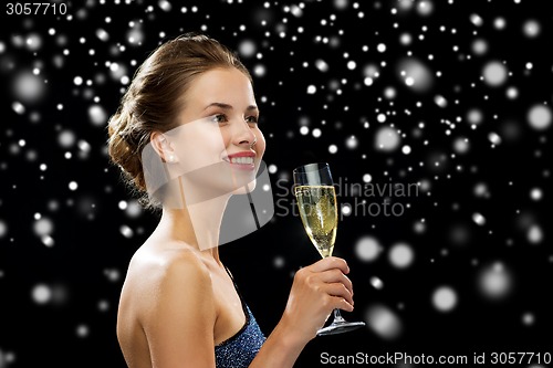 Image of smiling woman holding glass of sparkling wine