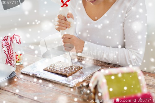 Image of close up of woman making gingerbread houses