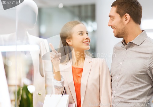 Image of happy young couple with shopping bags in mall