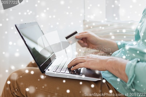 Image of close up of man with laptop and credit card