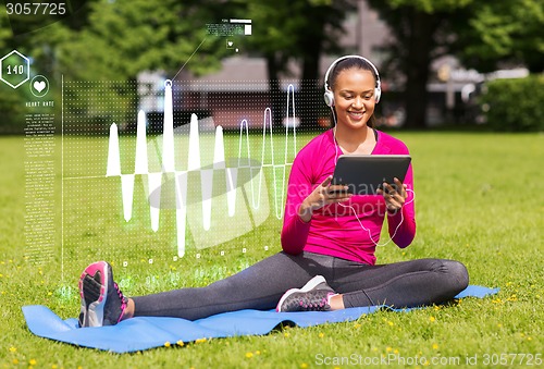 Image of smiling woman with tablet pc outdoors